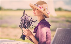 ラベンダーの花、帽子、椅子を持つ少女