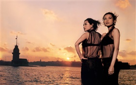 二つのアジアの女の子、日没、川、風